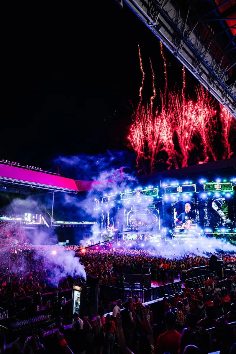 Artiest met microfoon in de lucht op het podium van Qmusic Foute Party 2026