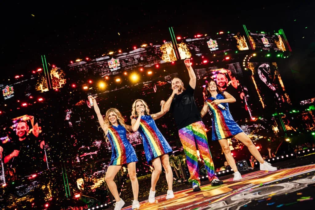Zangeressen in regenboogjurkjes op het podium tijdens Qmusic Foute Party 2026